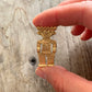 Broche vintage dieu maya métal doré